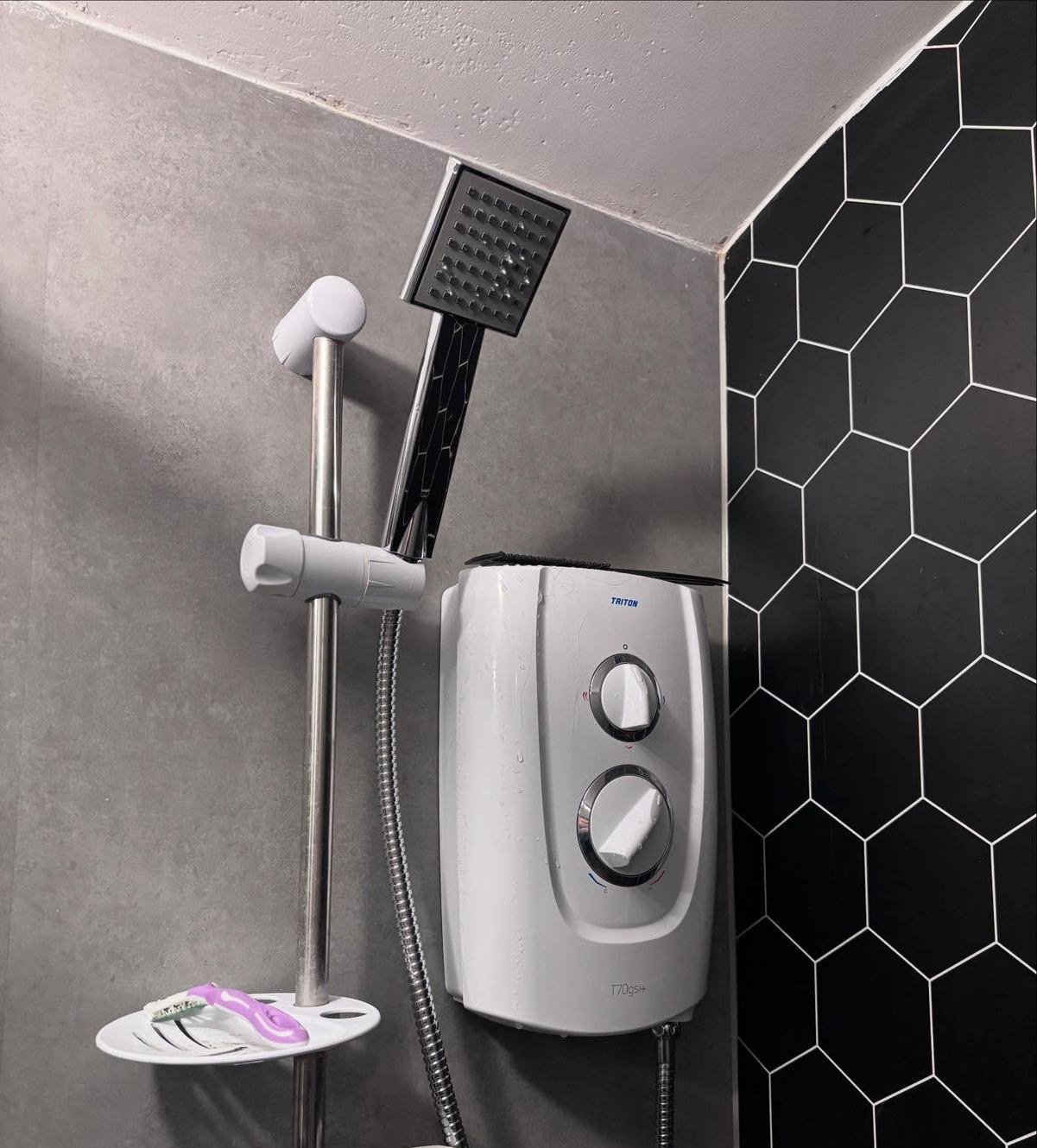 Electric shower installed with black hexagon wall tiles, finished by AJ Plumbing Works
