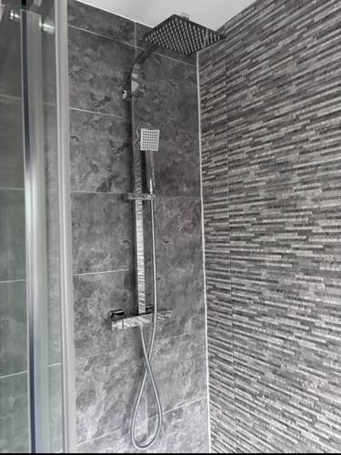 Shower installation with rainfall shower mixer and tiled walls
