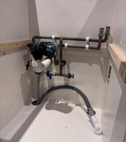 Macerator pump unit fitted under a bathroom cabinet