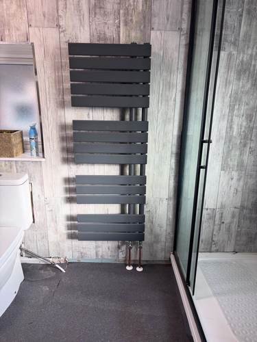 Anthracite heated towel rail in a shower room