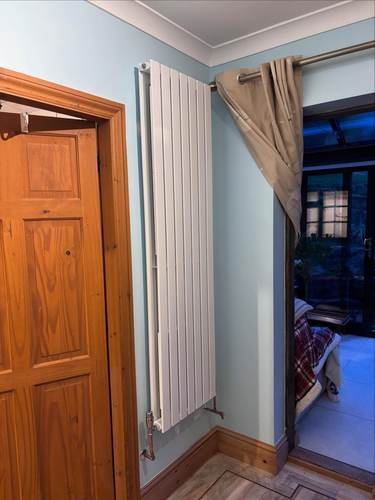 Vertical column radiator installed in a hallway