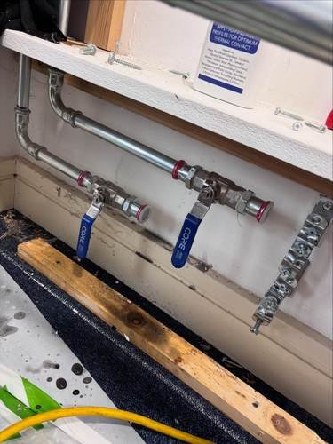 Heating pipework and isolation valves fitted to a wall