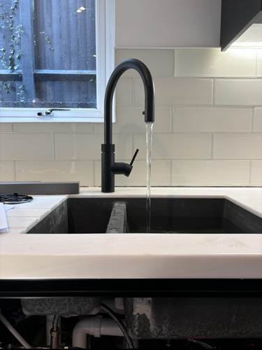 Kitchen sink with mixer tap running