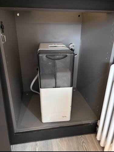 Water softener unit installed in a kitchen cabinet