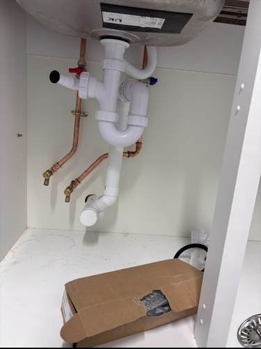 Copper pipework fitted under a new kitchen cabinet