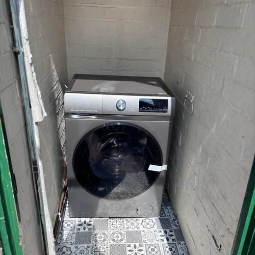 Washing machine installed in a tight utility cupboard