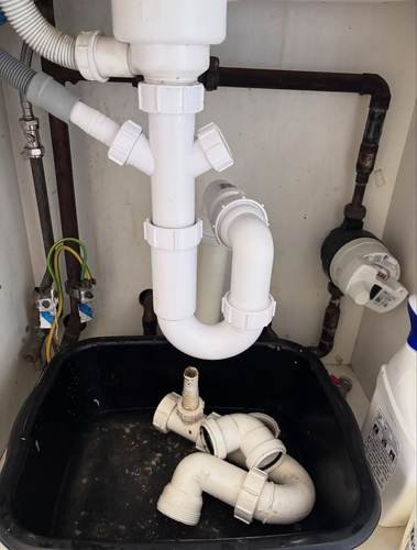 Under-sink pipework fitted above a utility sink